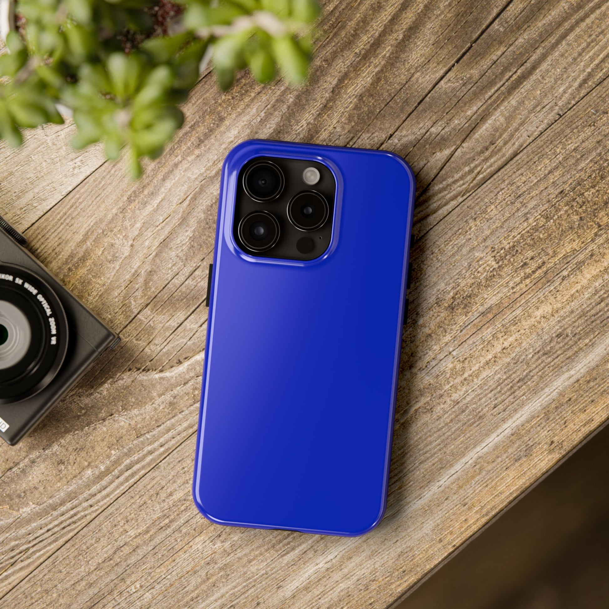 iPhone 15 Pro BMW San Marino Blue phone case on a table with accessories. 