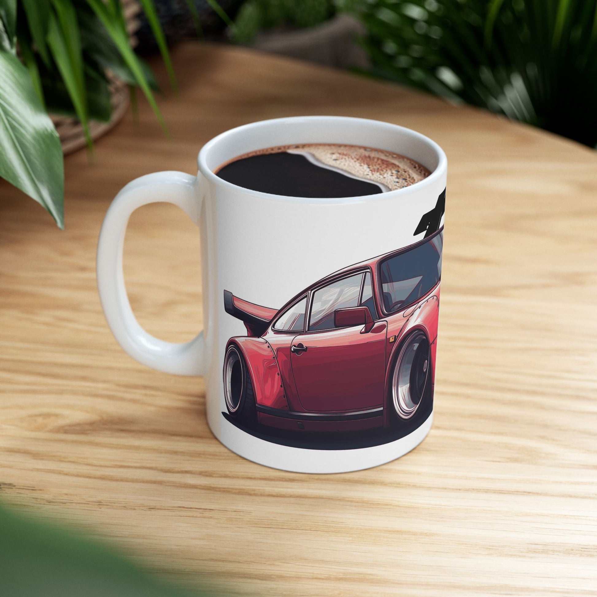 Lifestyle view of the 11oz White Coffee Mug with a red Porsche 930 with the text 'turbo' placed behind the car. 