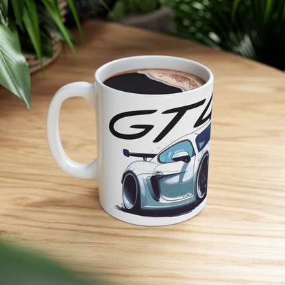 Lifestyle view of the 11oz White Coffee Mug with a Porsche Cayman GT4 RS with the GT4RS emblem placed above the car.  