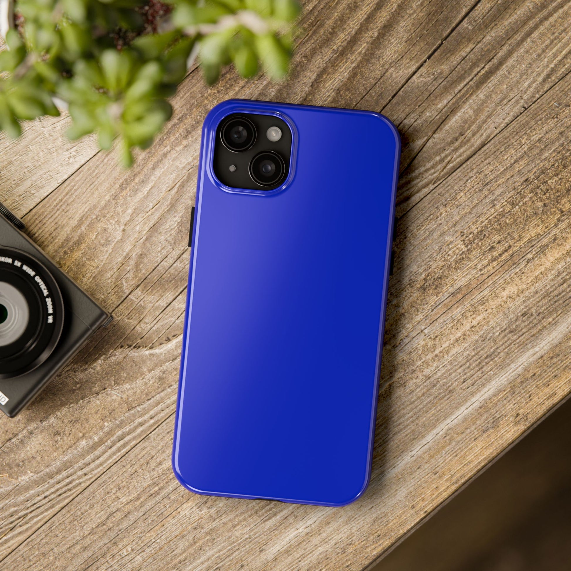 iPhone 15 Plus BMW San Marino Blue phone case on a table with accessories. 