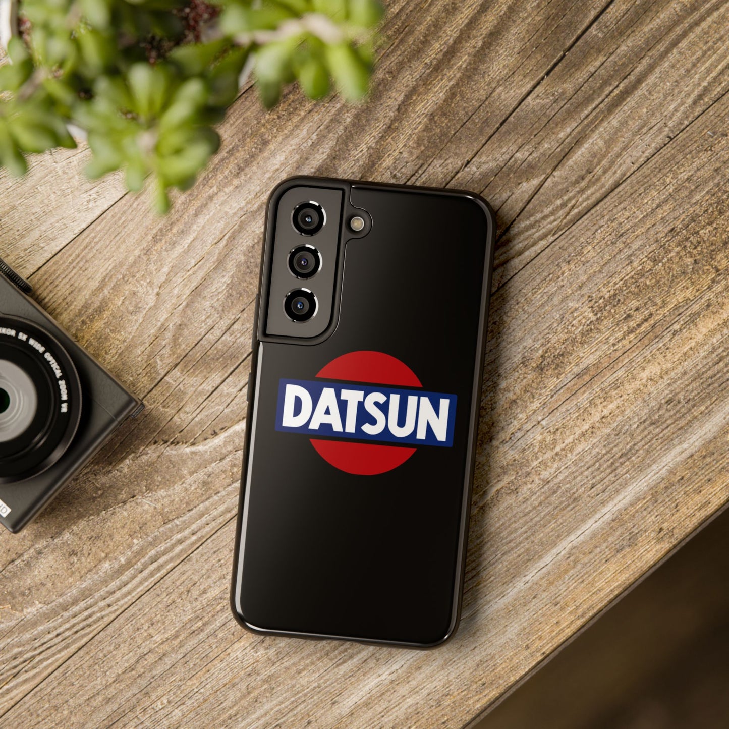 Black Samsung Galaxy S22 Datsun phone case on a table with accessories.