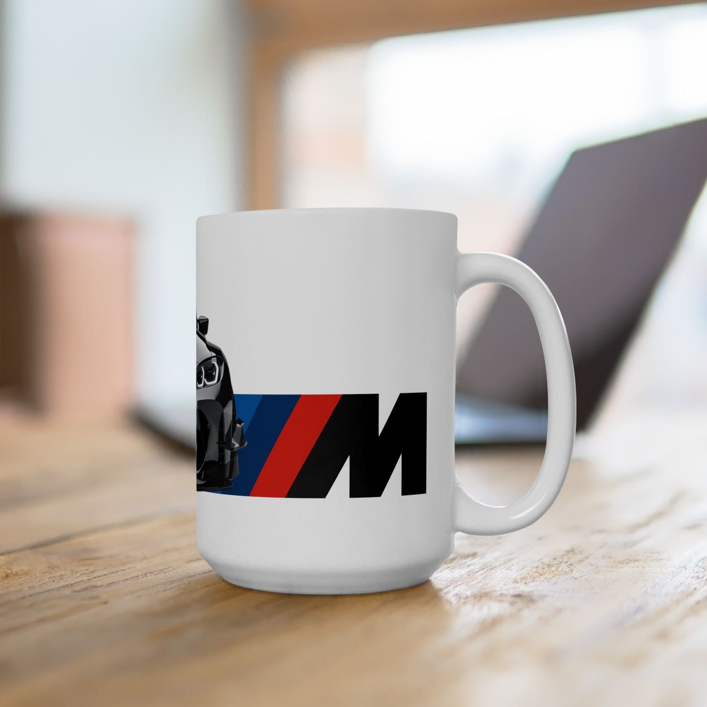 Lifestyle view of the 15oz White Coffee Mug with a BMW M4 GTS with the M emblem placed beside the car.   