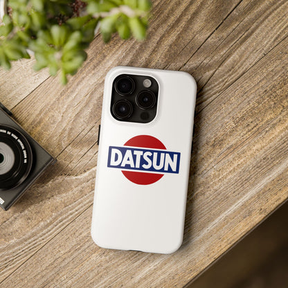 White iPhone 15 Pro Datsun phone case on a table with accessories.