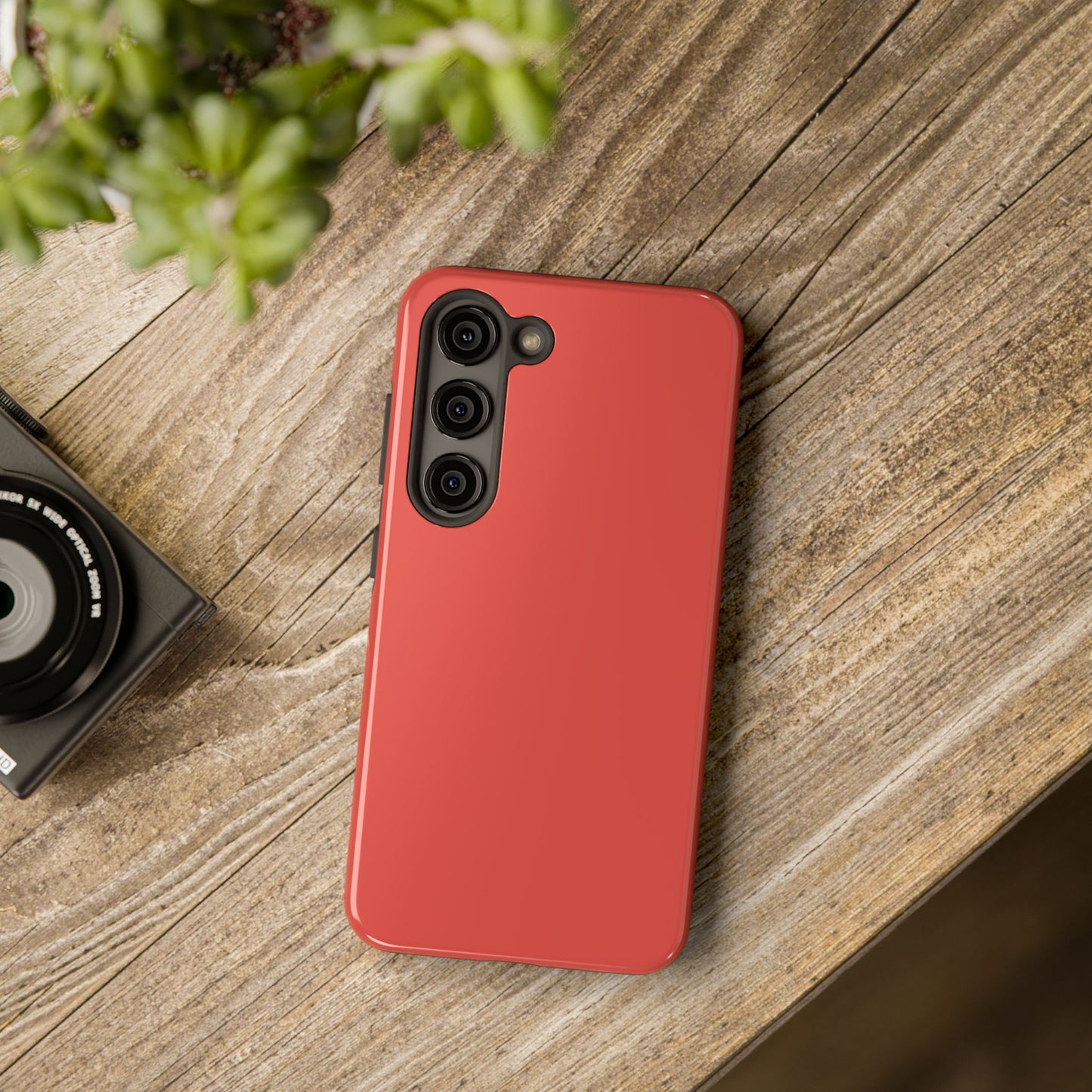 Samsung Galaxy S23 Max BMW Sakhir Orange phone case on a table with accessories. 