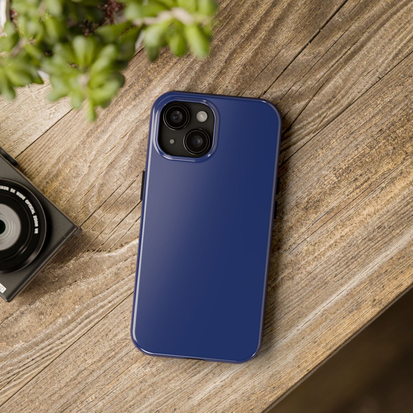 iPhone 15 BMW Tanzanite Blue phone case on a table with accessories. 