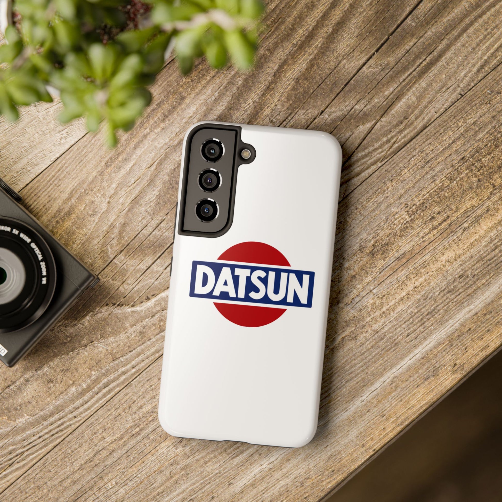 White Samsung Galaxy S22 Datsun phone case on a table with accessories.