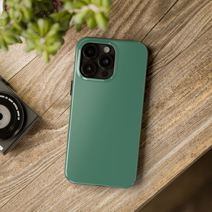 iPhone 15 Pro Max Aston Martin Racing Green phone case on a table with accessories. 