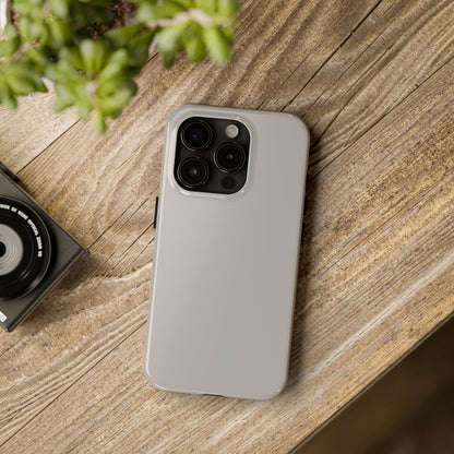 iPhone 15 Pro Aston Martin Silver Birch phone case on a table with accessories. 