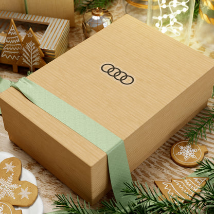 2 inch transparent sticker of the Audi emblem on a box for scale
