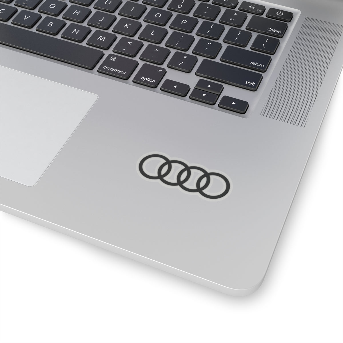 2 inch transparent sticker of the Audi emblem on a laptop for scale
