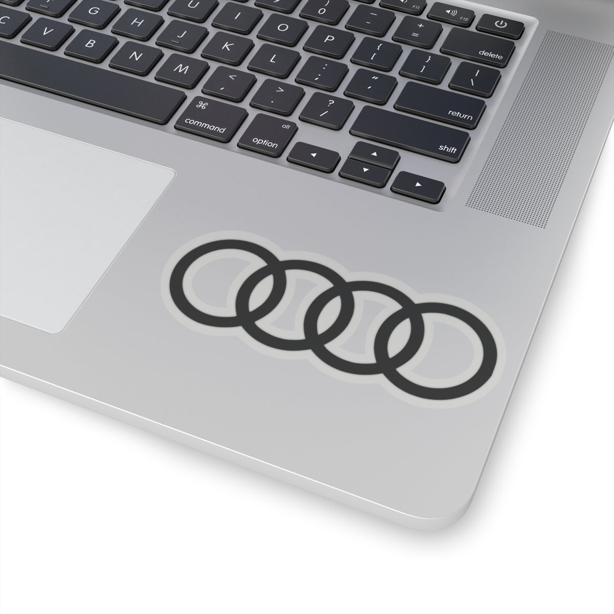 4 inch transparent sticker of the Audi emblem on laptop for scale
