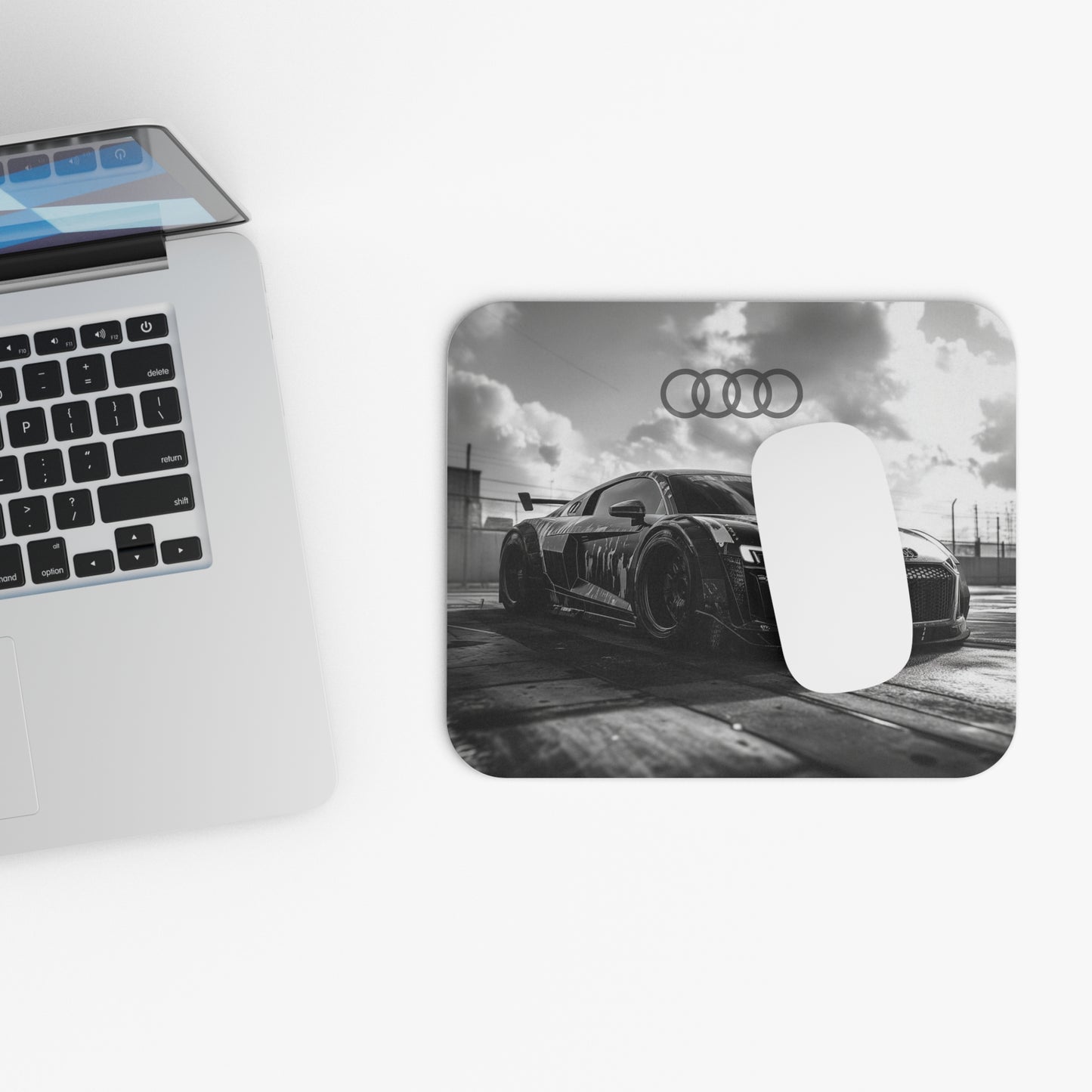 Audi R8 mouse pad and mouse placed beside a laptop