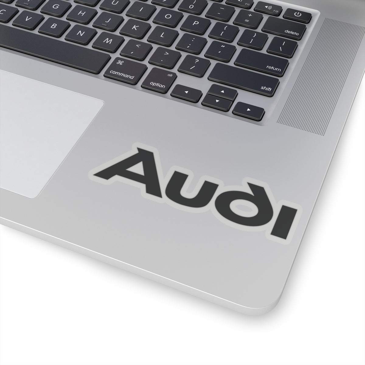 4 inch transparent sticker of the Audi logo on laptop for scale
