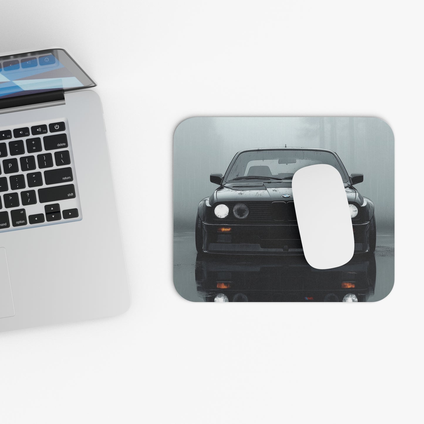 BMW E30 mouse pad and mouse placed beside a laptop