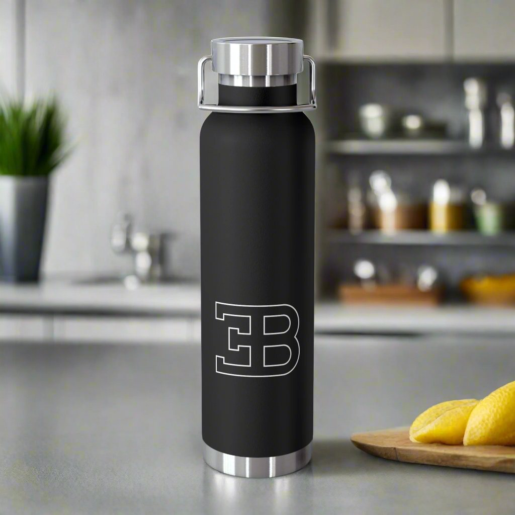 Front View of Black Bugatti Logo Water Bottle in a kitchen. Copper Vacuum Insulated. Bugatti-branded insulated water bottle