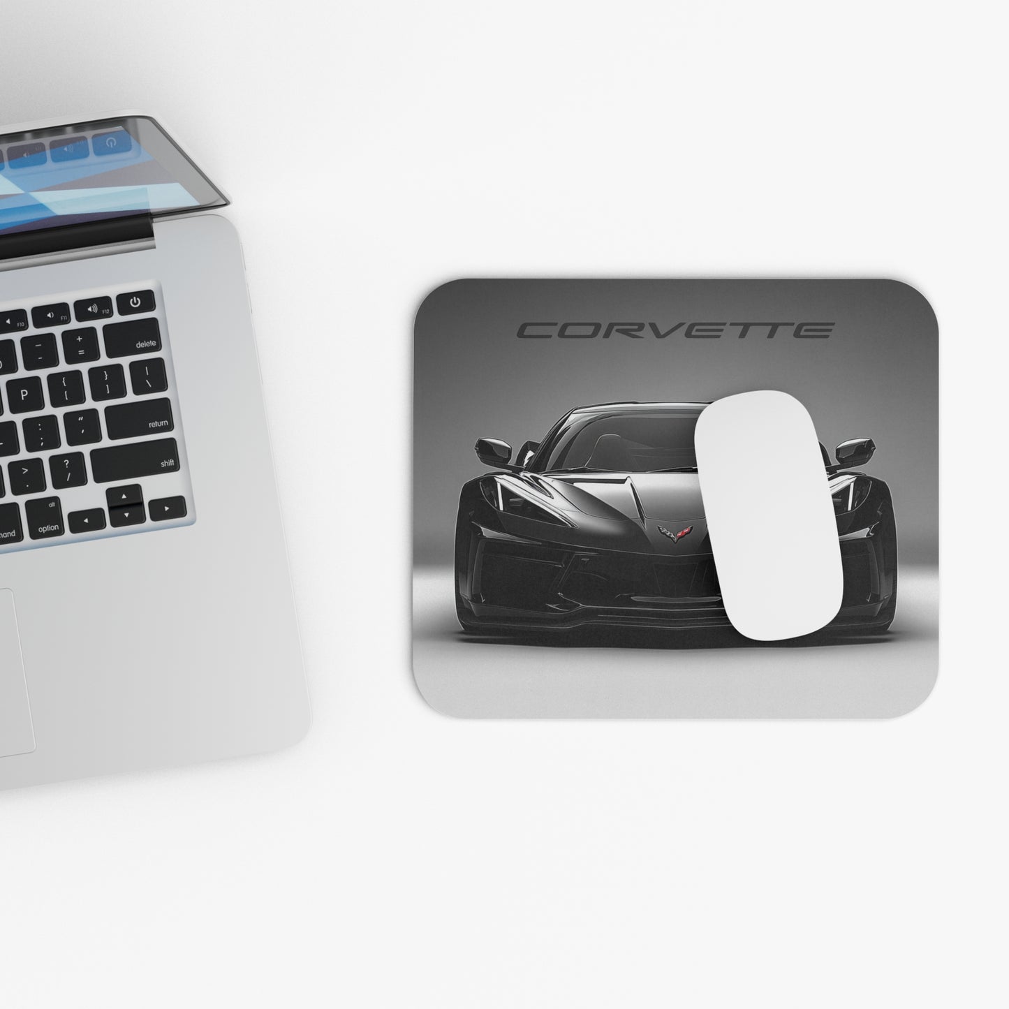 C8 Corvette mouse pad and mouse placed beside a laptop