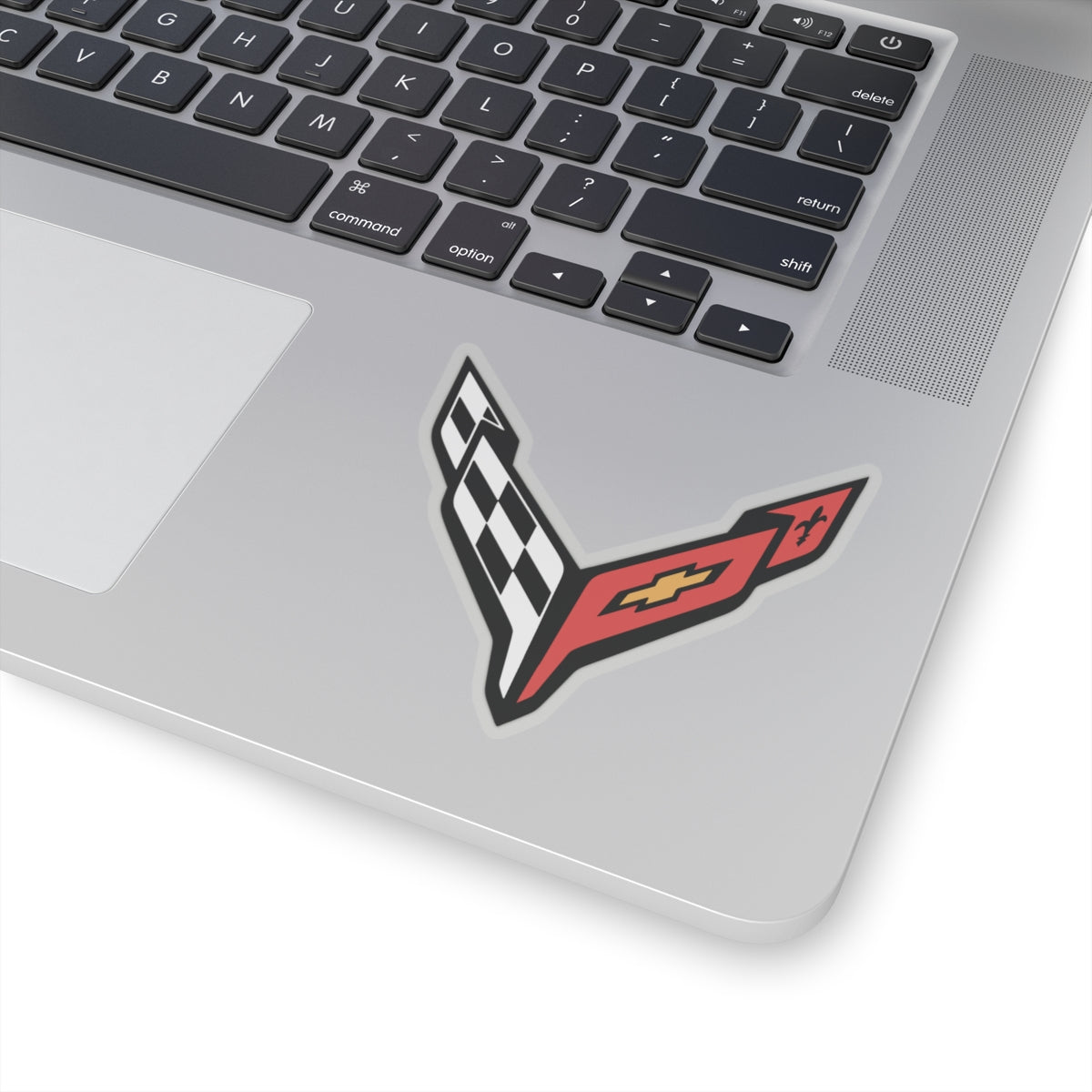 3 inch transparent sticker of the Corvette C8 emblem on laptop for scale
