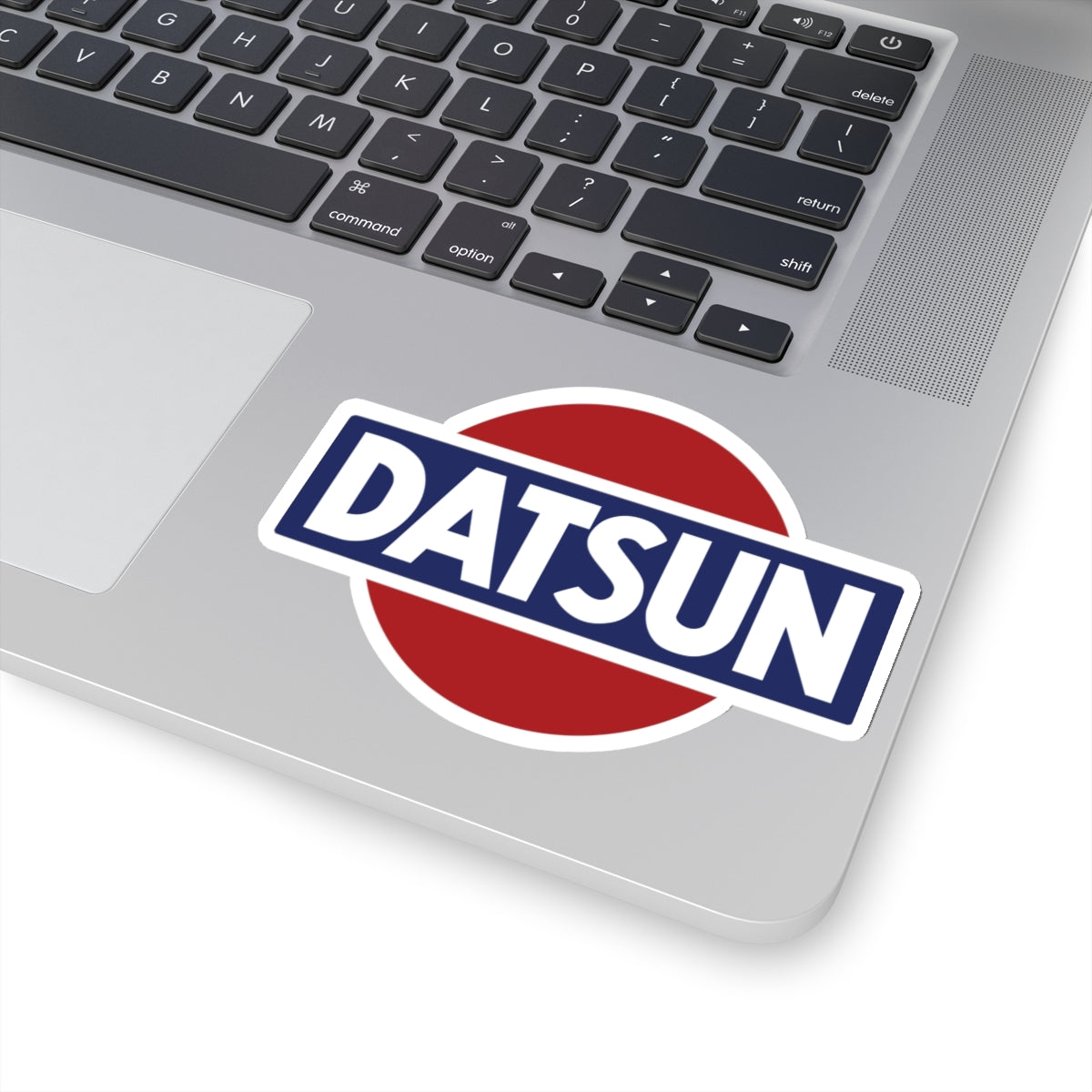 4 inch whtie Vintage Datsun sticker on a silver laptop