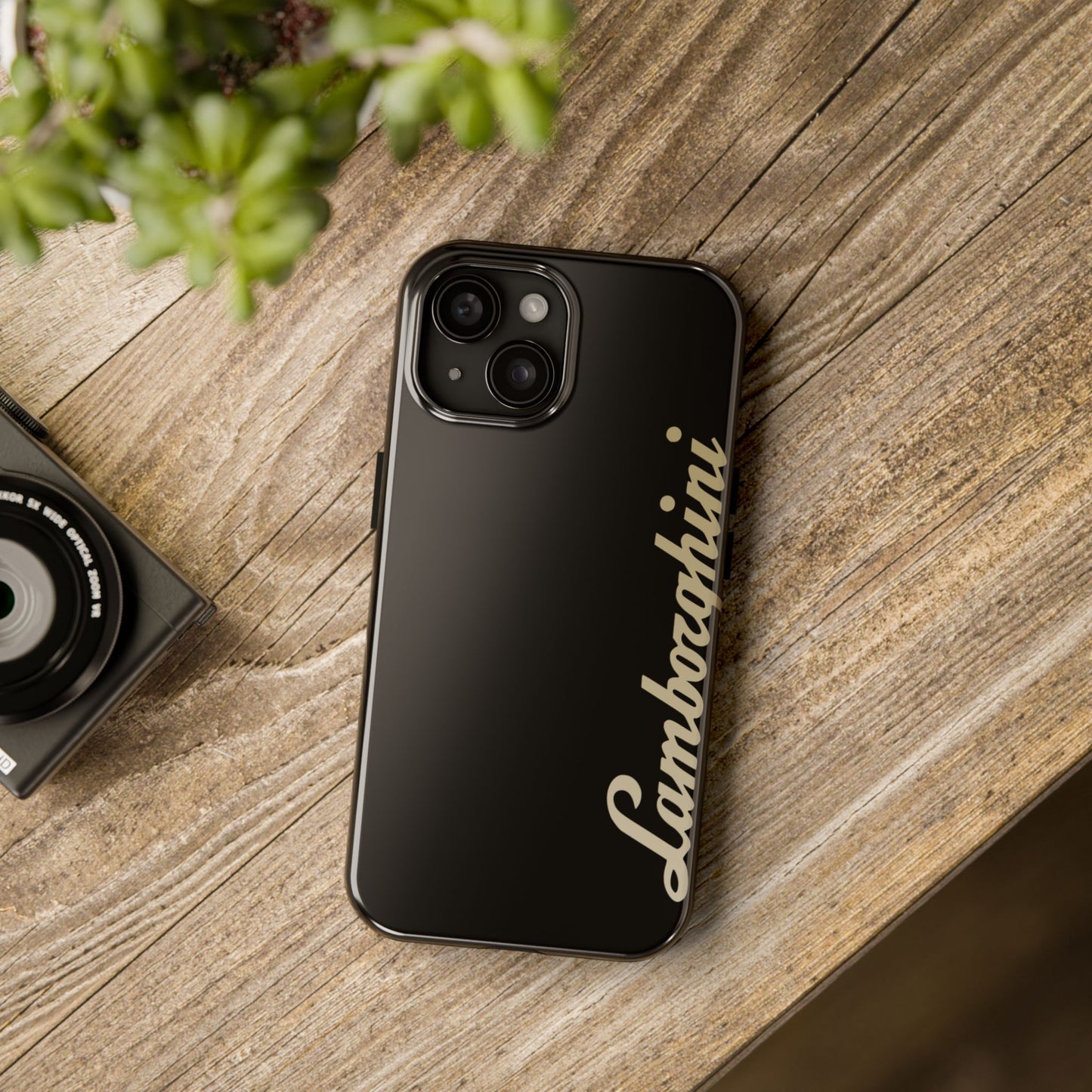 Black iPhone 15 Lamborghini phone case on a table with accessories.