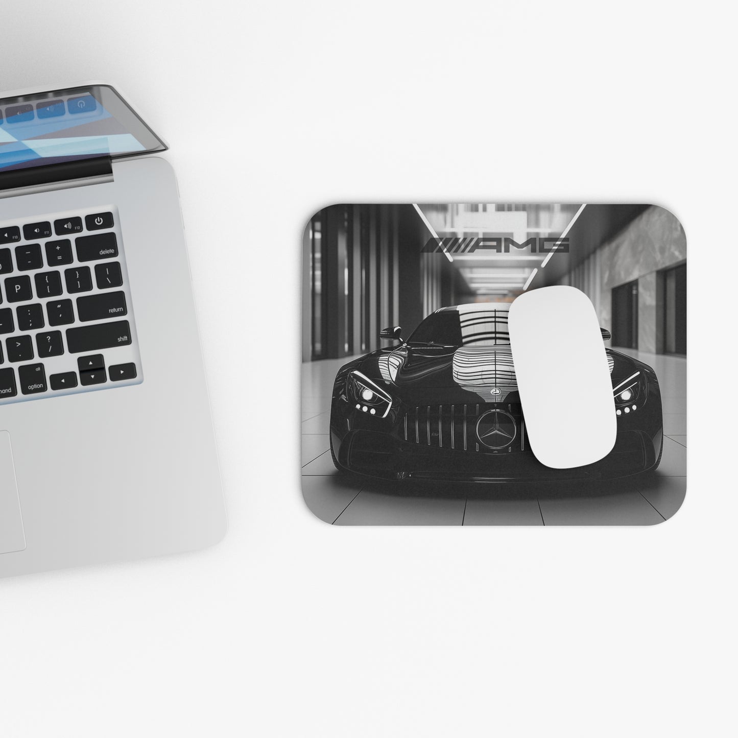 Mercedes-Benz AMG GT mouse pad and mouse placed beside a laptop