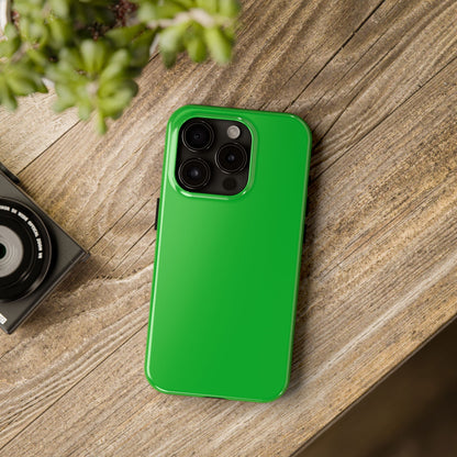 iPhone 15 Pro Porsche Signal Green phone case on a table with accessories. 