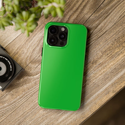 iPhone 15 Pro Max Porsche Signal Green phone case on a table with accessories. 