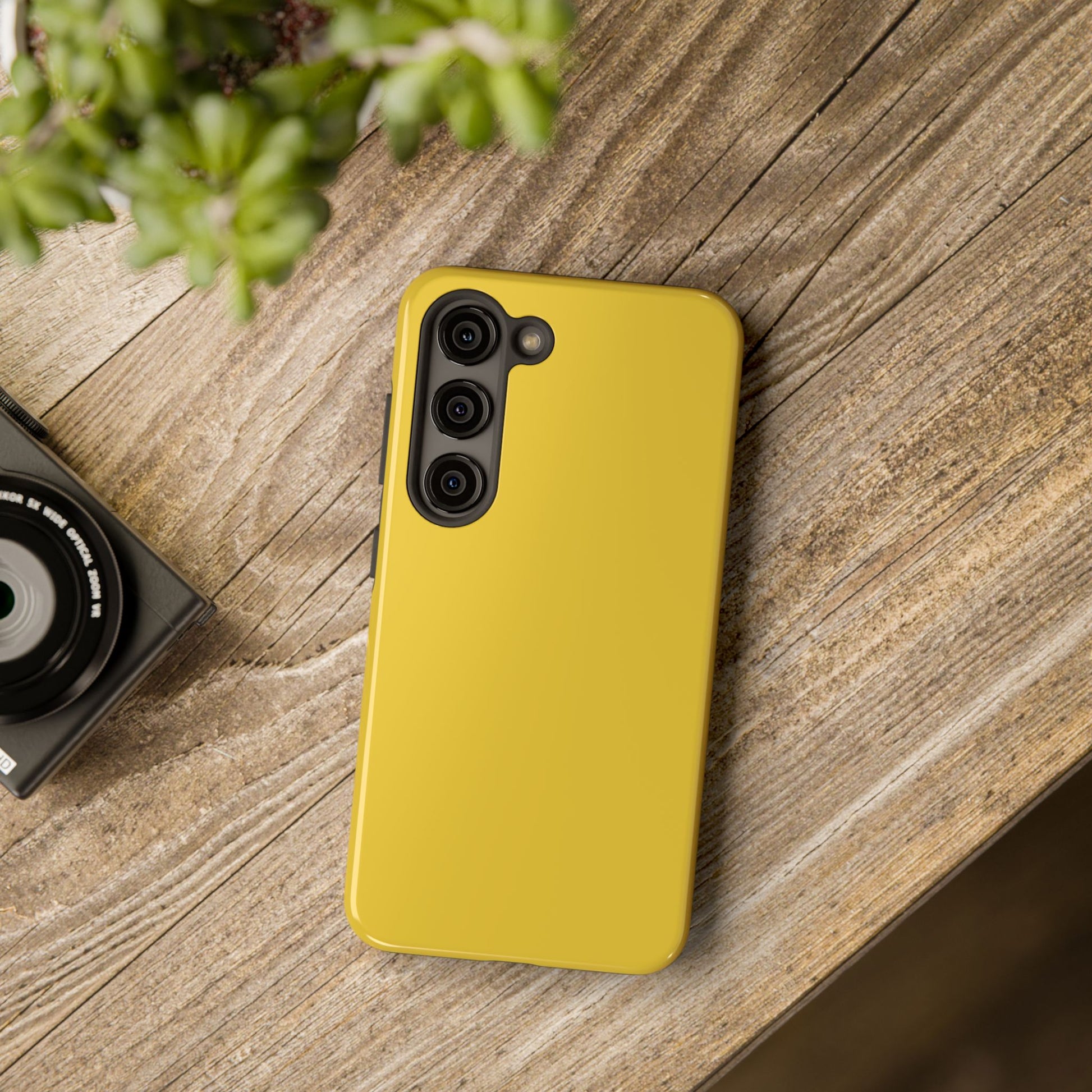 Samsung Galaxy S23 Max Porsche Speed Yellow phone case on a table with accessories. 