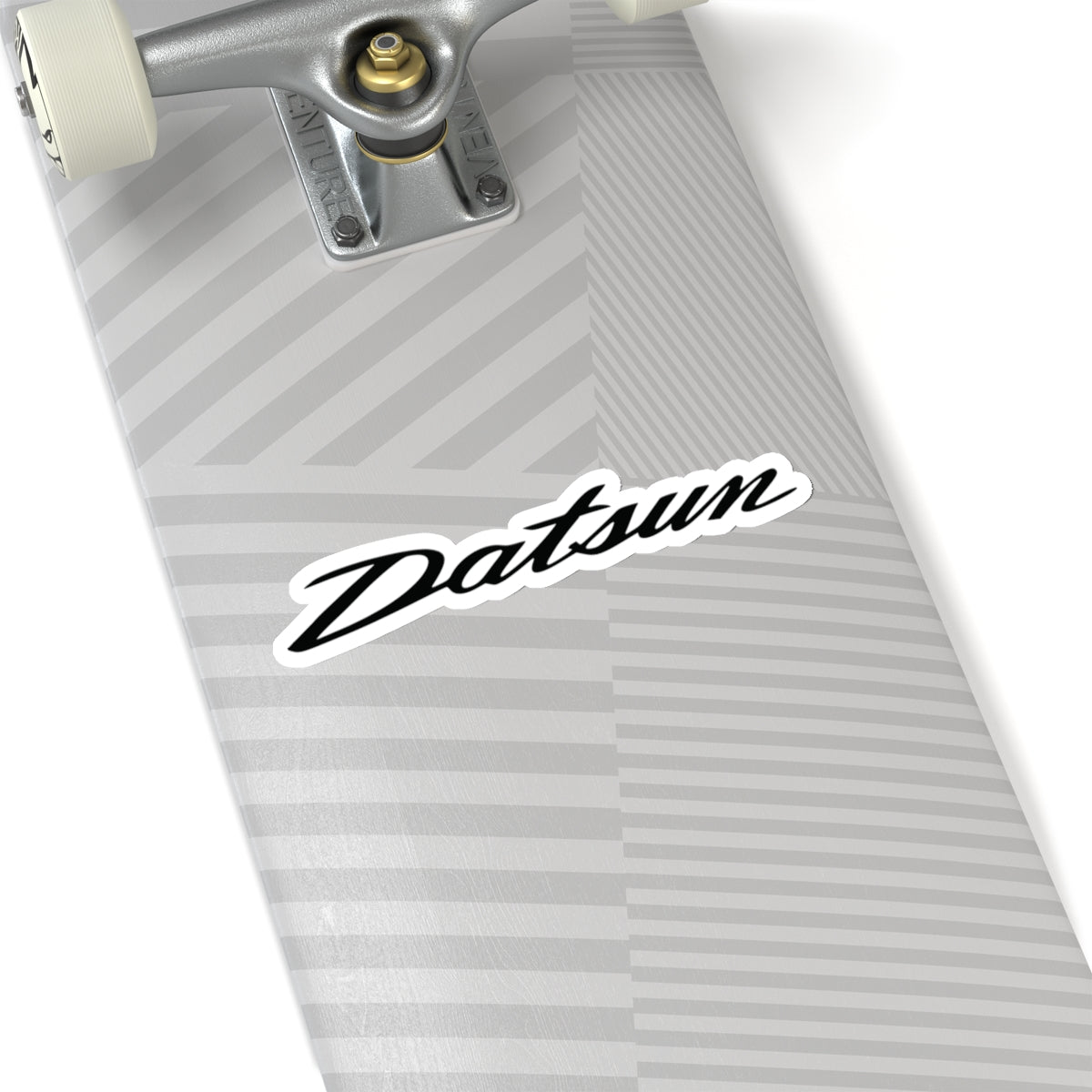 2 inch white Datsun sticker on a silver skateboard deck