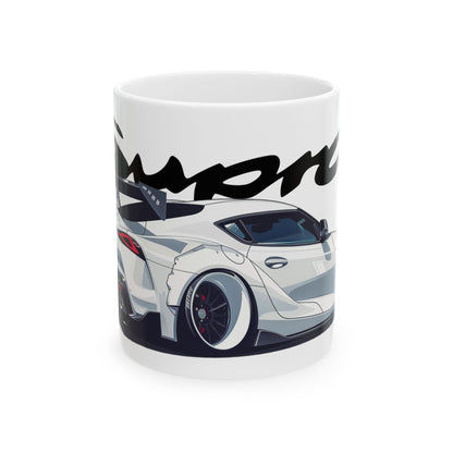 11oz White Coffee Mug with a 5th Generation Toyota Supra with the Supra emblem placed behind the car. 