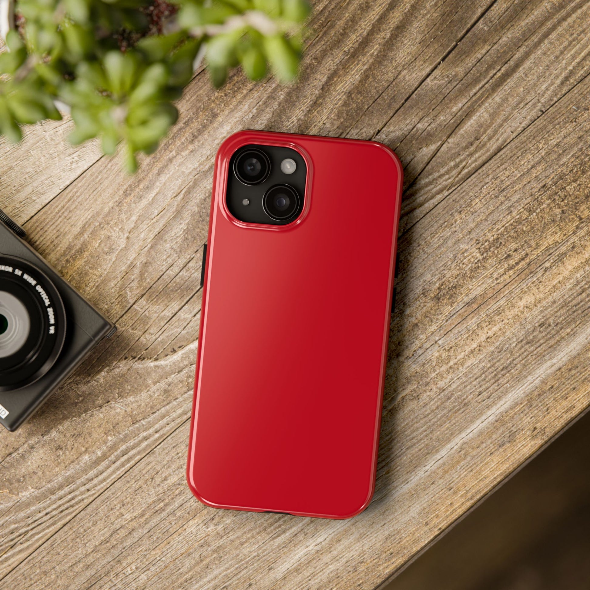 iPhone 15 Porsche Guards Red phone case on a table with accessories. 