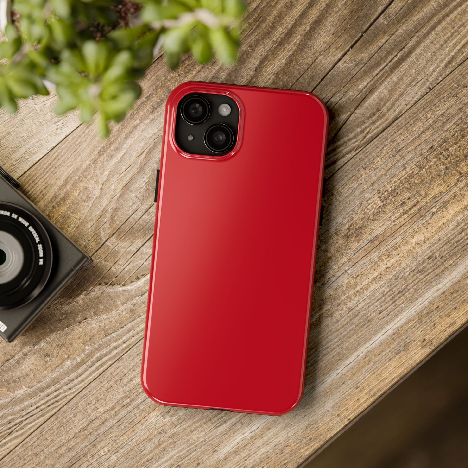 iPhone 15 Plus Porsche Guards Red phone case on a table with accessories. 