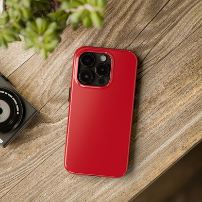 iPhone 15 Pro Porsche Guards Red phone case on a table with accessories. 