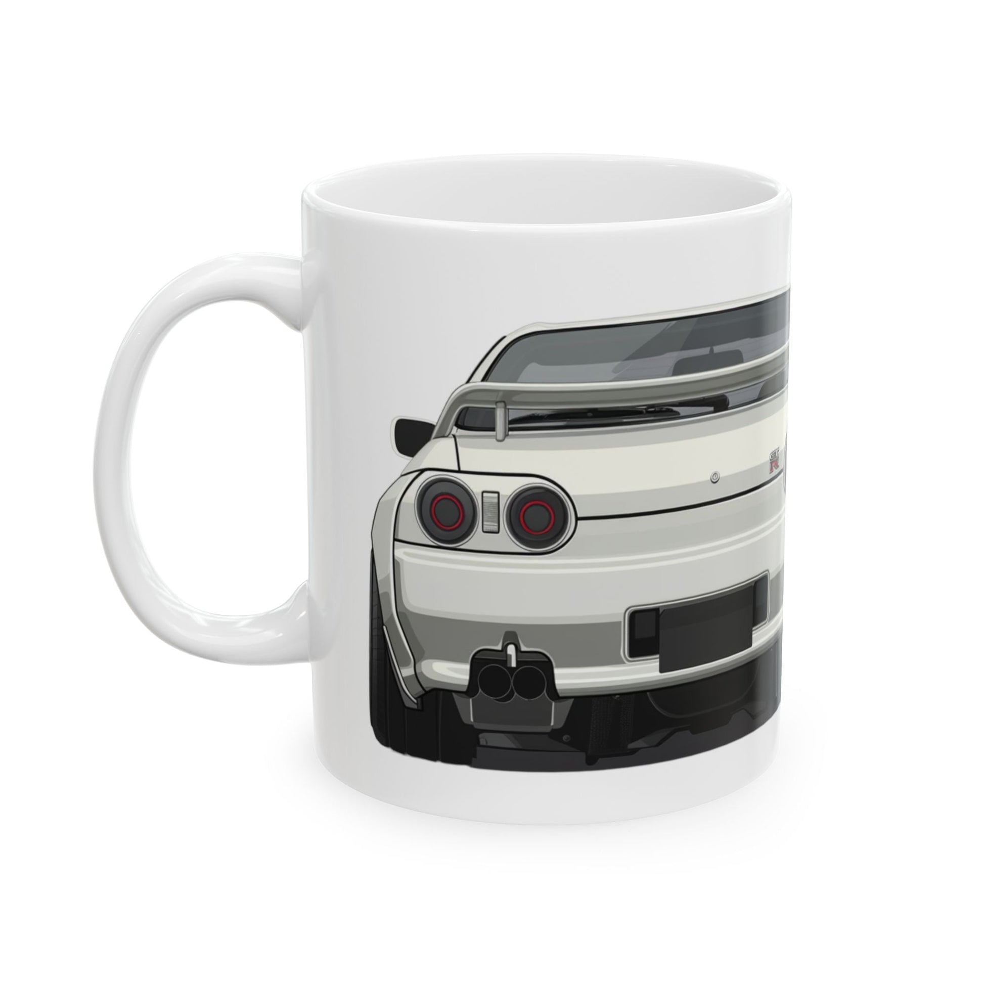 Left view of 11oz White Coffee Mug with a Nissan Skyline R32 with the GTR emblem placed behind the car.  